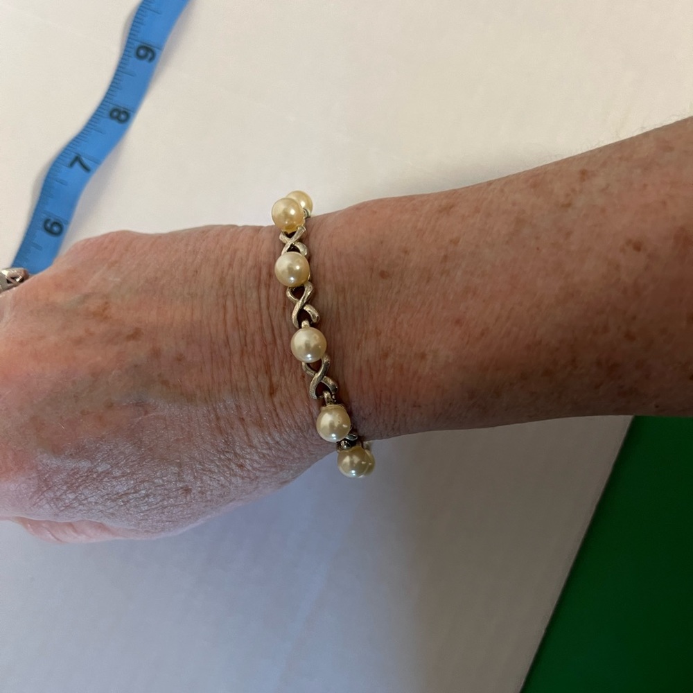 Beautiful unbranded pearl bracelet with exes in between the chain silver tone